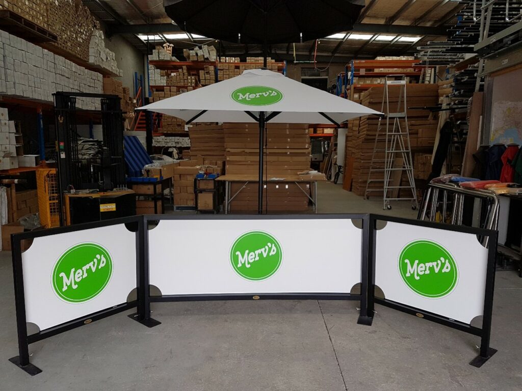 Market umbrella and cafe barriers with logos for cafe