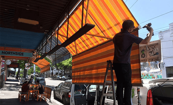 A man setup outdoor awnings for cafe